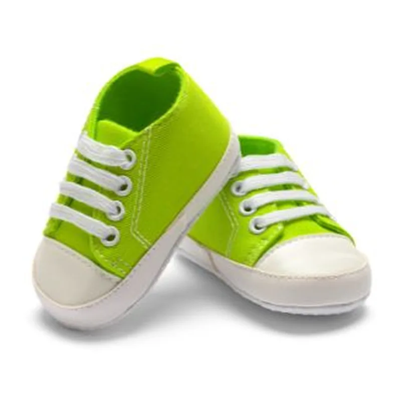 A pair of lime green children's sneakers on a white background