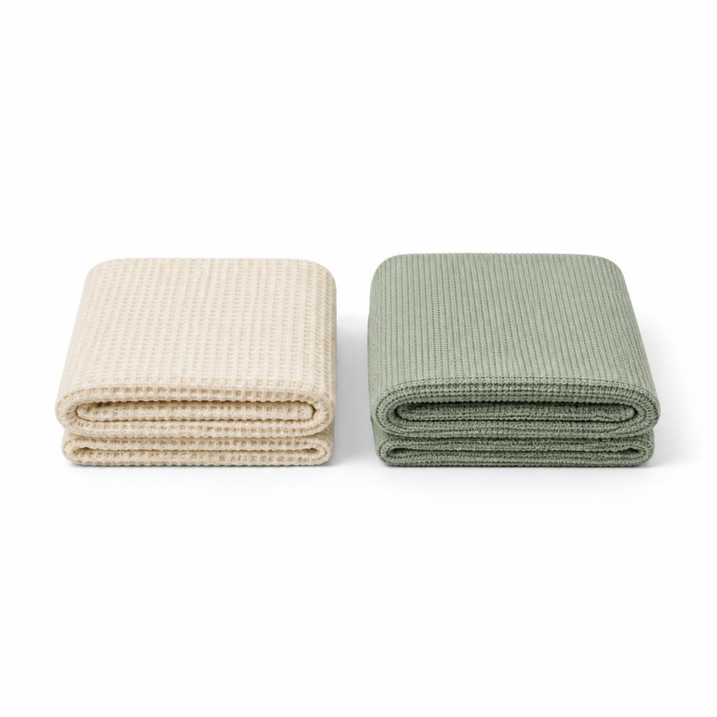 Two folded cotton cot blankets on a white background
